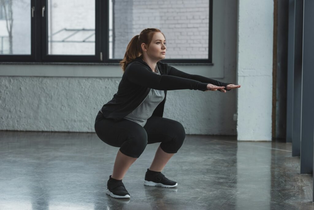 Curvy girl doing squat in gym