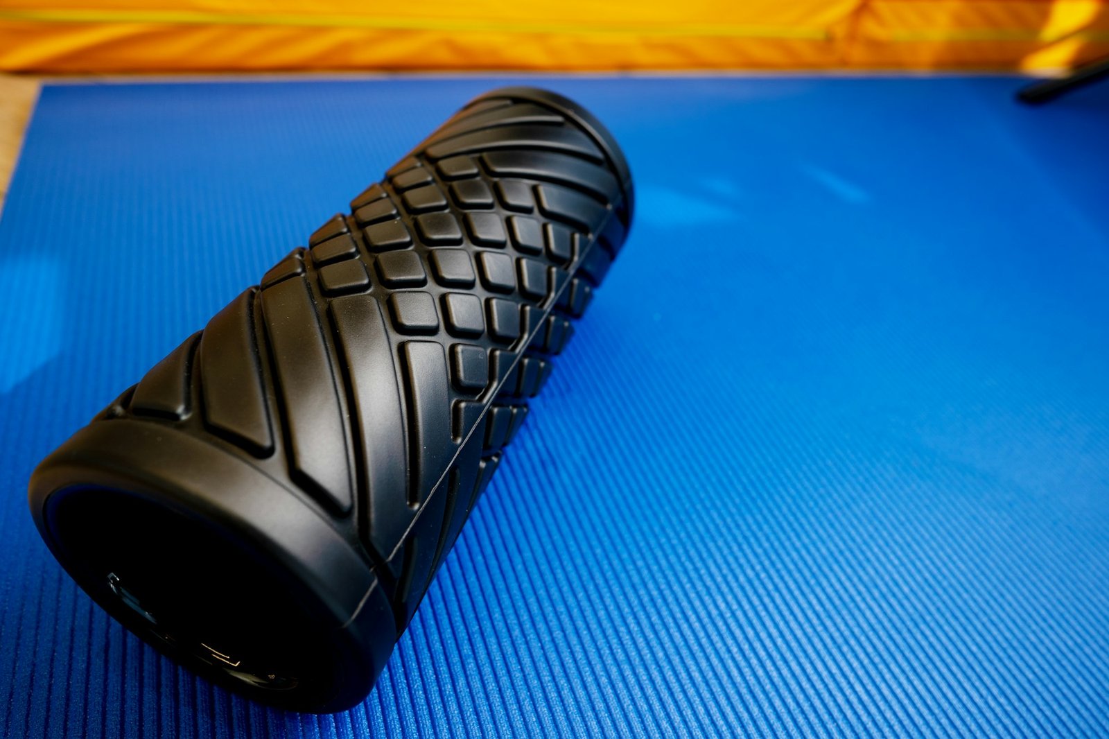 Sport fitness foam roller on blue mat